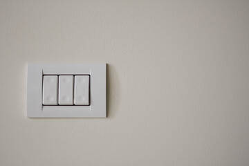 Contemporary modern electric light switches on on a light living room wall. House home utilities...
