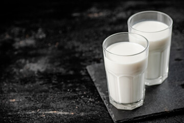 A glass of fresh milk on a stone board. 