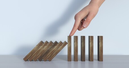Hand stopping wooden domino business crisis effect or risk protection concept