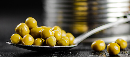 Canned green peas in a spoon. 