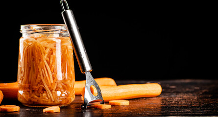 Canned carrots in a glass jar on the table.