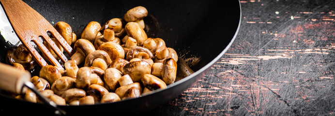Small fried mushrooms in a frying pan. 