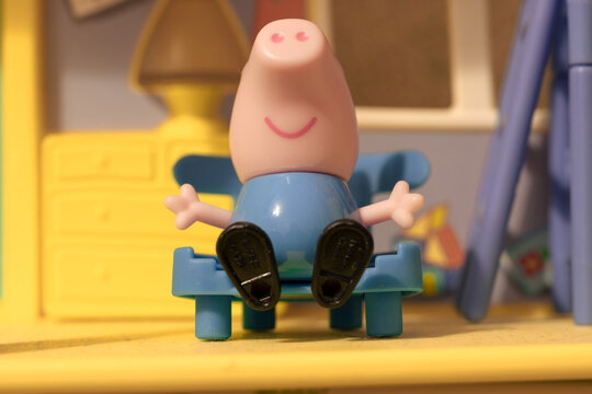 Peppa Pig's toy house. Little piggy George sits on a chair