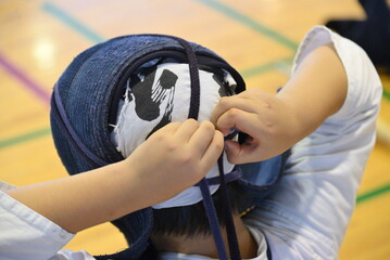剣道の面をつけている少年剣士 © harunon