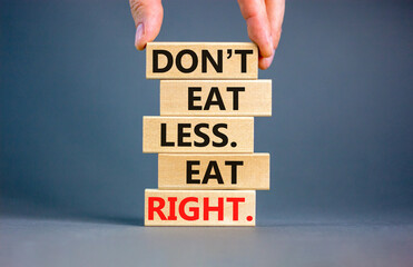 Eat less or right symbol. Concept words Do not eat less, eat right on wooden blocks. Beautiful grey table grey background. Doctor hand. Healthy lifestyle and eat less or right concept. Copy space.