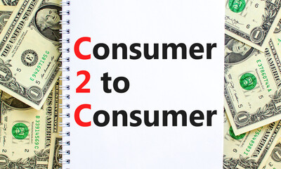 C2C consumer to consumer symbol. Concept words C2C consumer to consumer on white note on a beautiful background from dollar bills. Business and C2C consumer to consumer concept. Copy space.