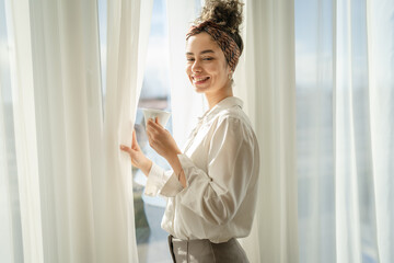 One woman have a cup of coffee at the window in bright morning or day