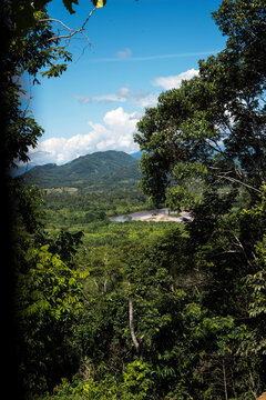 mountain view from above with some green view,rain forest hills with layering of mountain , and the village on the far with river amazonic jungle ,tingo maria peru and sky clouds