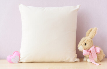Easter mockup pillow with bunny and easter eggs on pink cover background, copyspace. Cushion pink...