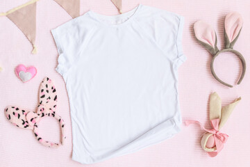 Easter mockup white t-shirt with bunny and easter eggs on pink cover background. Flatlay, top view, copyspace.