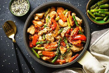 Chicken stir fry with vegetables at stone background. Flat lay image.
