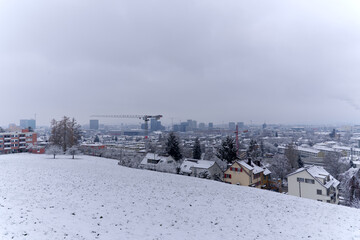 Obraz na płótnie Canvas Aerial view over snow covered City of Zürich with skyline and gray cloudy winter sky on a snowy late autumn day. Photo taken December 17th, 2022, Zurich, Switzerland.