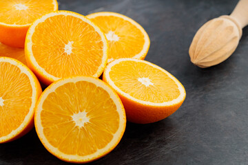 Fototapeta na wymiar Fresh orange halves on a dark background. Juicy citrus fruits for making juice