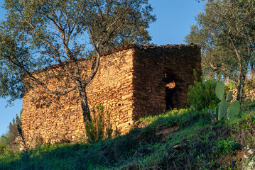 Cabaña de piedra en estado ruinoso al amanecer.