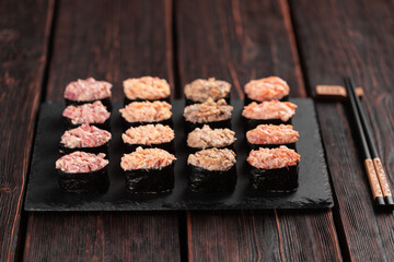 Set of Gunkan Maki Sushi with different types of fish salmon, scallop, perch, eel, shrimp and caviar on wooden table background. Sushi menu. Japanese food sushi set gunkans