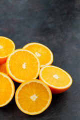 Halves of ripe oranges on a dark background. Sliced oranges for breakfast. Copy space
