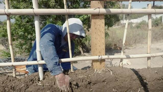 man building a wall with bioconstruction techniques