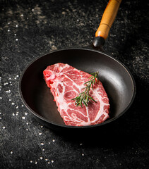 Raw pork steak in a frying pan. 