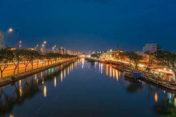 Fototapeta premium Springtime in Saigon, boat on canal, transport spring flower for Tet to Ben Binh Dong open air market, Vietnamese happy with Lunar New Year, Vietnam