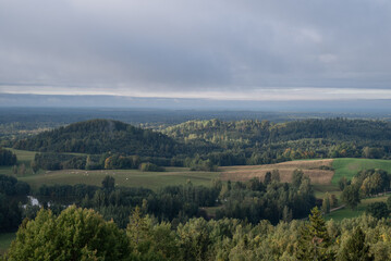 Obraz premium Foggy forest hills and fields touched by morning sun in autumn landscape