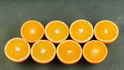 Halves of juicy oranges on a green background. Half cut oranges for making juice. Close up