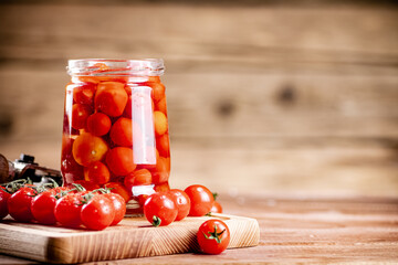 Pickled ripe tomatoes in a glass jar. 