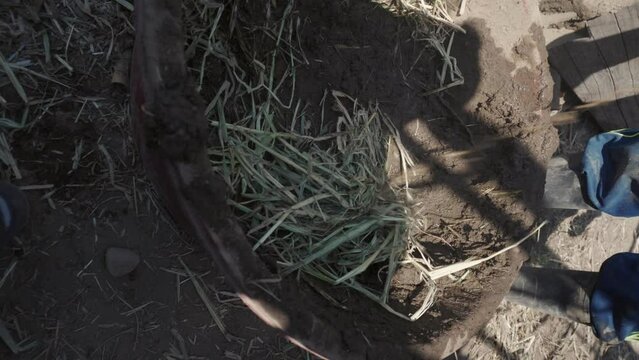 person mixing straw and earth for the technical construction of bioconstruction