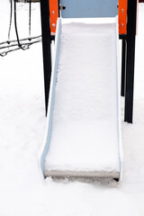 snow-covered empty slide on the street, on the playground