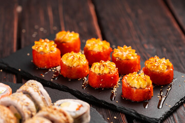 Japanese salmon sushi with spicy mayonnaise and tobiko caviar - Sushi menu norimaki and uramaki. Asian cuisine concept
