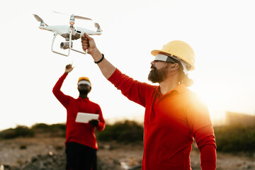 Drone engineers working with futuristic glasses on construction site - Aerial engineering and...
