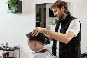 Barber shaving caucasian man in barber shop.