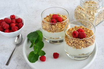 healthy dessert with raspberry, yogurt, granola and mint leaves isolated on white background