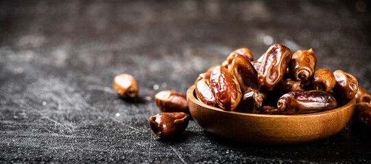 Full wooden plate with dates on the table. 