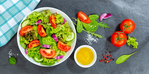 Mixed salad with fresh tomatoes healthy eating food from above banner on a slate