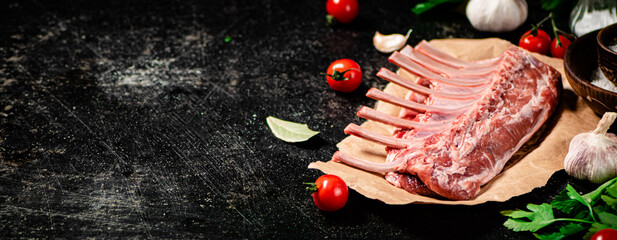 Raw rack of lamb with parsley and tomatoes. 