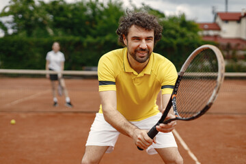 Portrait of tennis player standing in court with a racquet