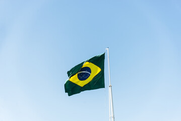 Flag of Brazil fluttering in the wind. In the center of the flag with the words "order and progress" in Portuguese.