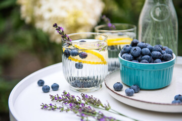 Two glasses with delicious homemade lemonade made of fresh blueberries, lemon and lavender on white...
