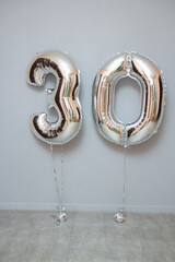 foil balloons numbers three and zero of silver color. Anniversary 30 years