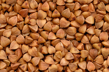 Macrophoto of buckwheat. Texture, dry buckwheat background. Hypoallergenic filler for pillows. Prevention of anemia.