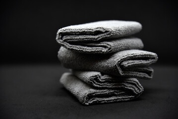 Three gray towels on a black background. Terry cloths for wiping furniture. Towels on a black...