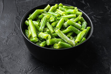 Green beans. Fresh frozen beans for salad, cooking or raw vegan food, in bowl, on black stone background