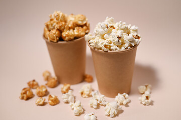 Two types of popcorn in two paper cups. Сaramel-covered and salted popcorn. Shallow depth of field.