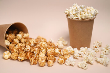 Two types of popcorn in two paper cups. Сaramel-covered and salted popcorn. Shallow depth of field.
