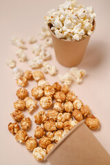 Two types of popcorn in two paper cups. Сaramel and salted popcorn. Shallow depth of field, top view.