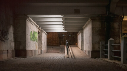 Urban city street traffic under bridge underpass at night