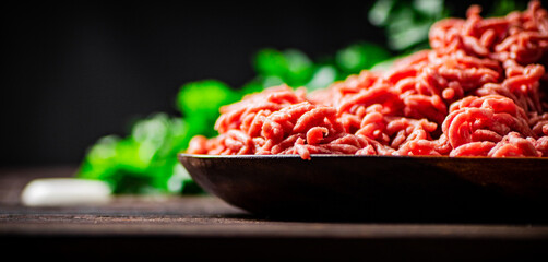Minced meat on a plate on the table with parsley. 