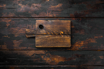 Old wooden kitchen board, top view flat lay , with copy space for text or food, on old dark  wooden table background