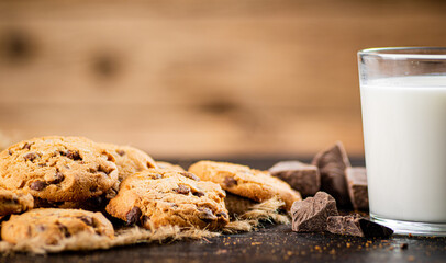 Cookies with pieces of milk chocolate with a glass of milk. 