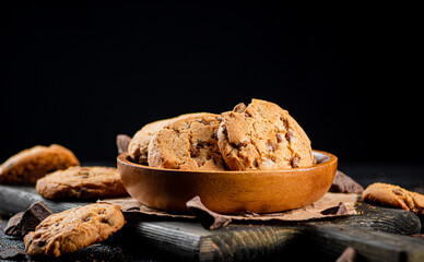 Cookies with pieces of milk chocolate on a cutting board. 